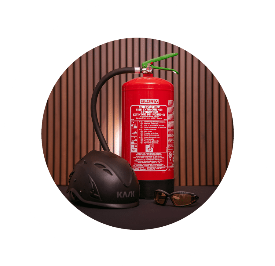 Das Bild zeigt einen Feuerlöscher, Helm und eine Schutzbrille